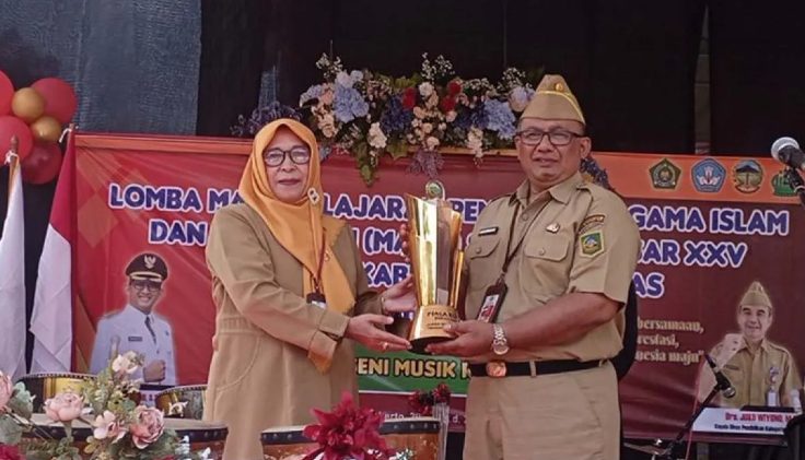 Sekretaris Daerah Banyumas Agus Nur Hadie (kanan) menerima Piala Bergilir Bupati Banyumas dari perwakilan Korwilcam Dinas Pendidikan (Dindik) Kecamatan Purwokerto Timur untuk diperebutkan kembali dalam Lomba Mapsi SD XXV Tingkat Kabupaten Banyumas Tahun 2024 di halaman Kantor Dindik Kabupaten Banyumas, Purwokerto, Banyumas, Jawa Tengah, Senin (29/7/2024). (FOTO: Antara).