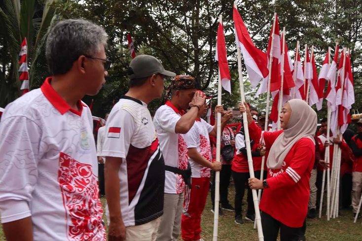 Bupati Purbalingga Dyah Hayuning Pratiwi menyerahkan Bendera Merah Putih kepada 18 camat se-Purbalingga untuk dibagikan kepada masyarakat dalam pencanganan Gerakan 10 Juta Bendera Merah Putih Tingkat Kabupaten Purbalingga di Lapangan Desa Binangun, Kecamatan Mrebet, Purbalingga, Jumat (9/8/2024. (FOTO: Pemkab Purbalingga)